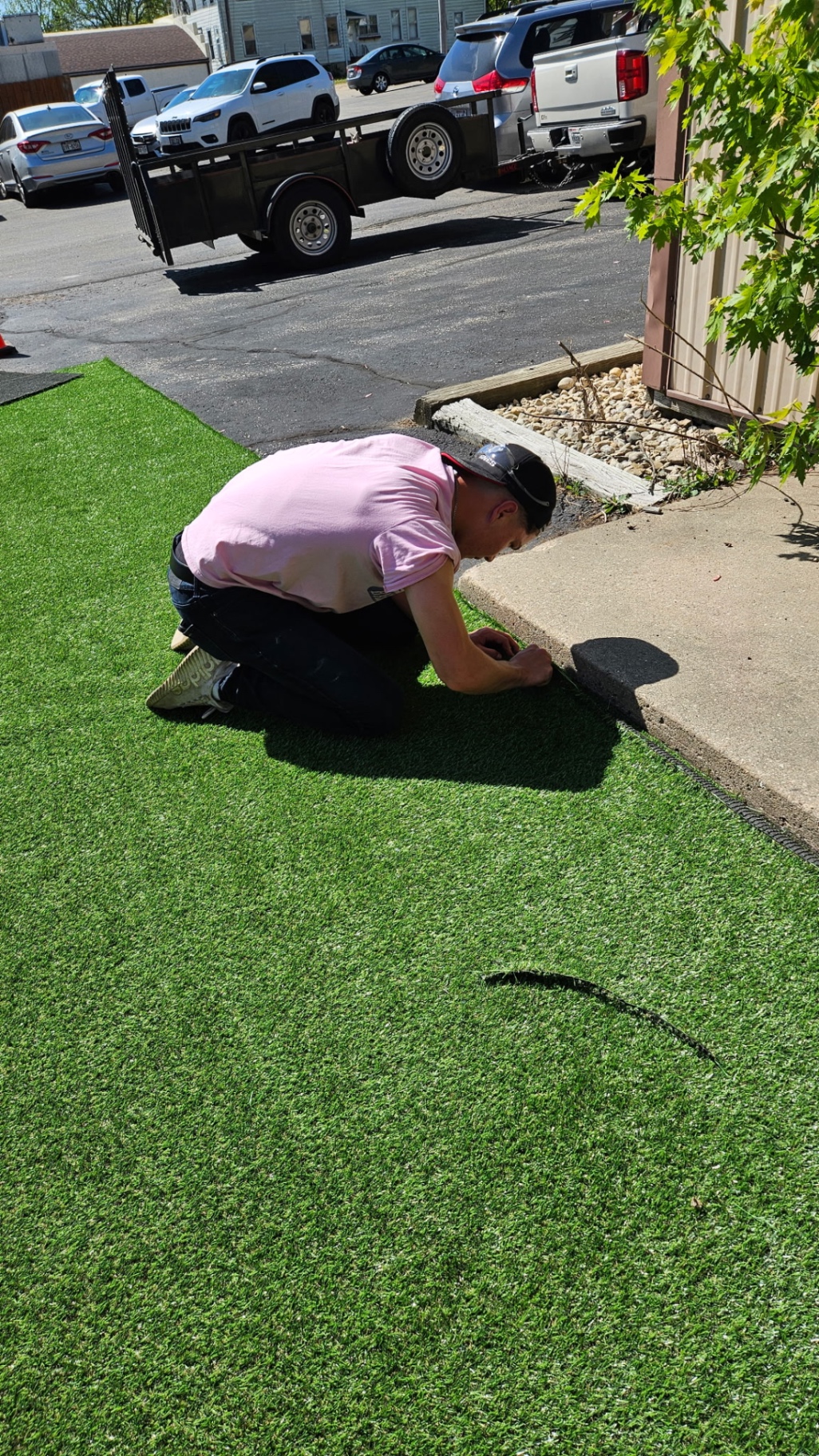 JJ Lawn Care owner installing artificial turf on-site